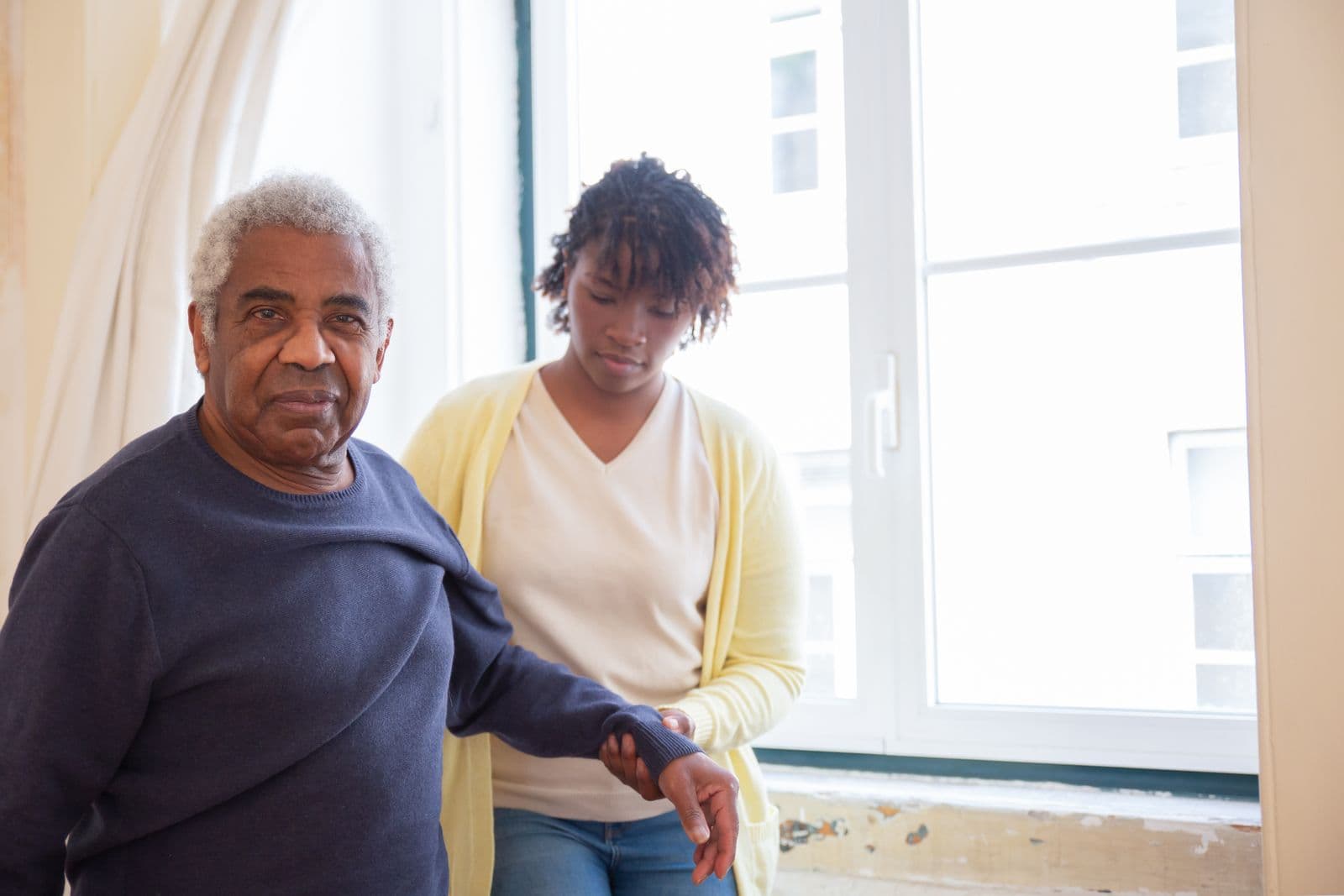 A carer offering steady arm support at home